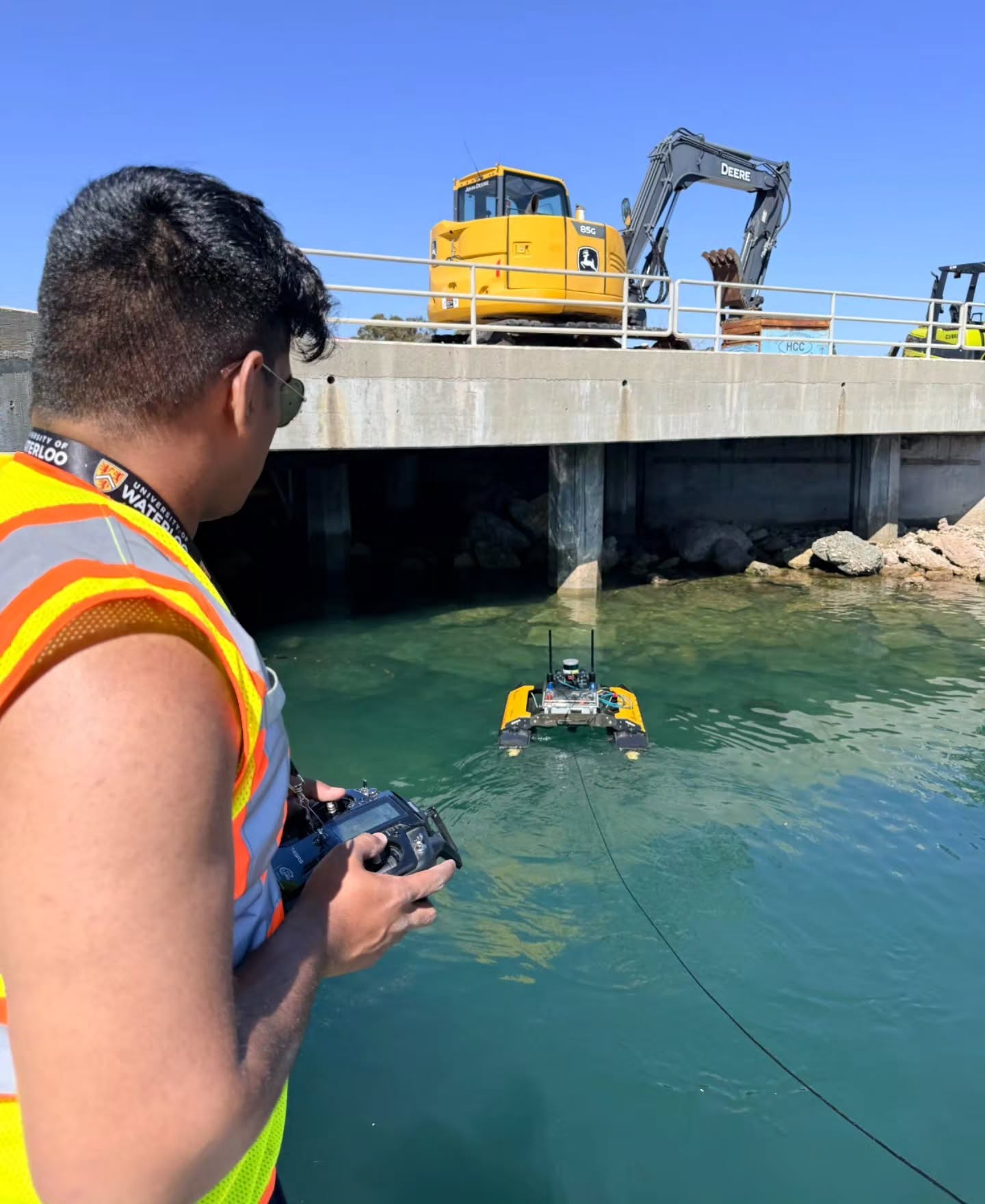 Aaron John Sabu operating a Heron unmanned surface vehicle during field testing